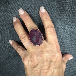 Ring Rhinestones surround purple iridescent simulated stone. Ring size 7 3/4